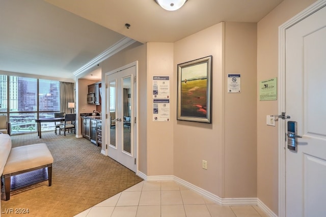 hallway with ornamental molding, french doors, and baseboards