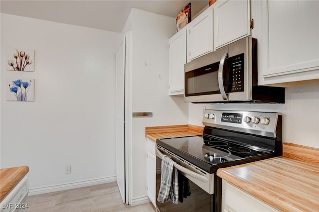 kitchen featuring stainless steel appliances, light hardwood / wood-style flooring, and white cabinets