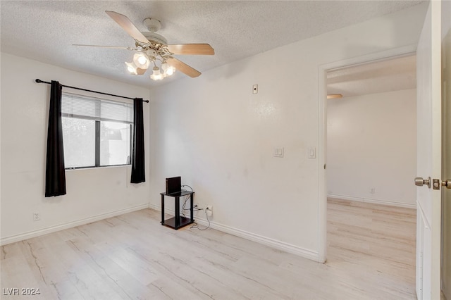 unfurnished room with ceiling fan, a textured ceiling, and light hardwood / wood-style floors