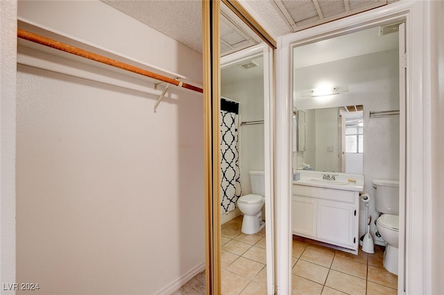 bathroom featuring tile patterned floors, vanity, and toilet