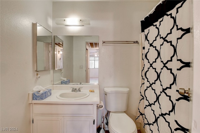 bathroom with toilet, vanity, and walk in shower