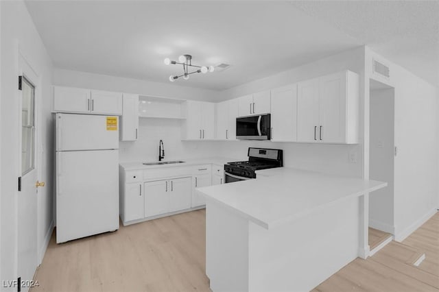 kitchen with sink, white cabinetry, stainless steel appliances, light hardwood / wood-style floors, and kitchen peninsula