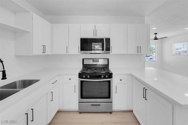 kitchen featuring white cabinetry, appliances with stainless steel finishes, and kitchen peninsula