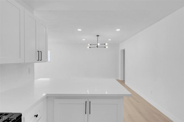 kitchen with hanging light fixtures, a notable chandelier, and white cabinets