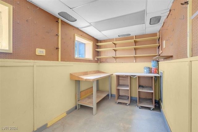 basement featuring a paneled ceiling and a workshop area