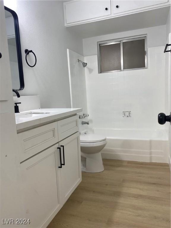 full bathroom featuring vanity, hardwood / wood-style floors, toilet, and tiled shower / bath