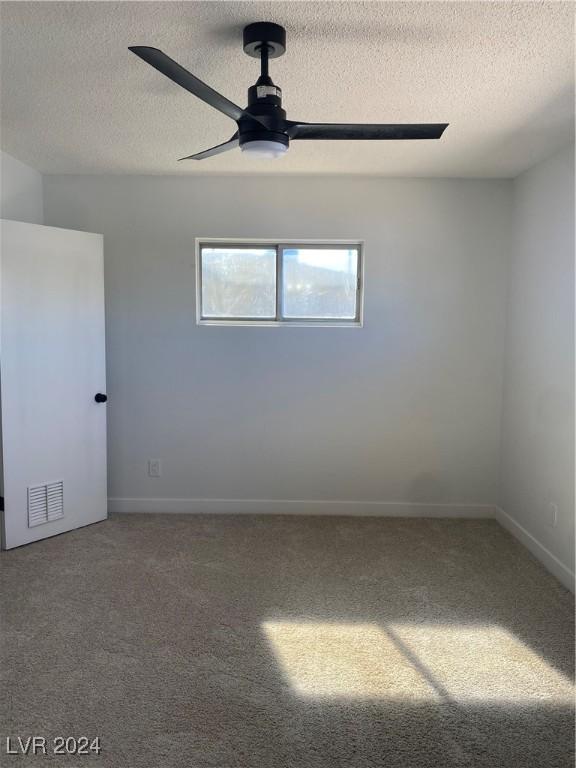 spare room with ceiling fan, carpet floors, and a textured ceiling