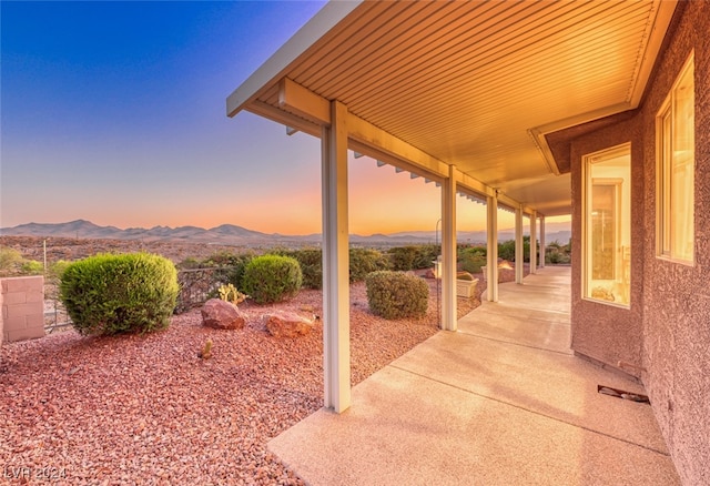 patio terrace at dusk featuring a mountain view