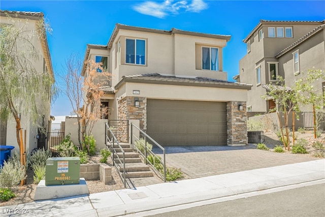 view of front of property with a garage and cooling unit