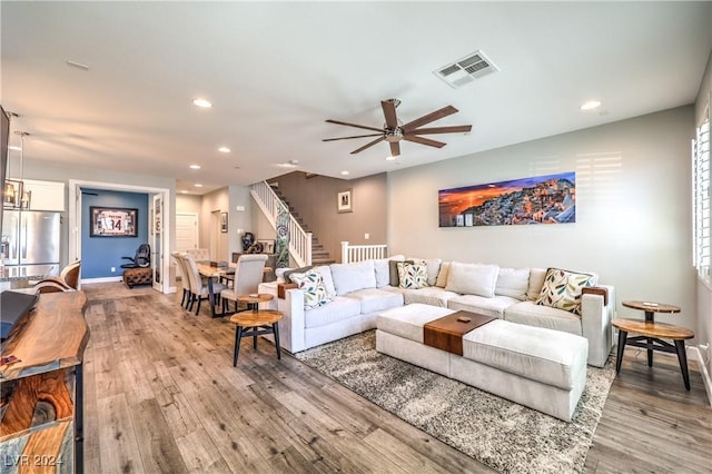 living room featuring light wood-type flooring and ceiling fan