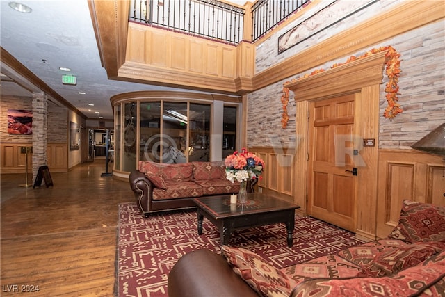 interior space featuring a towering ceiling, crown molding, and wood-type flooring