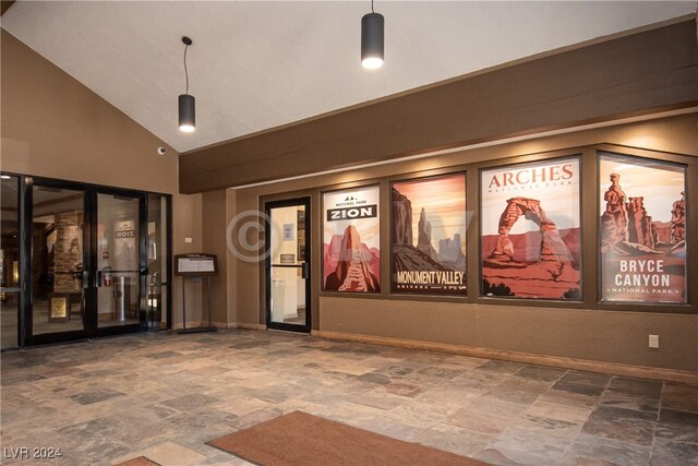 tiled home theater featuring high vaulted ceiling and french doors