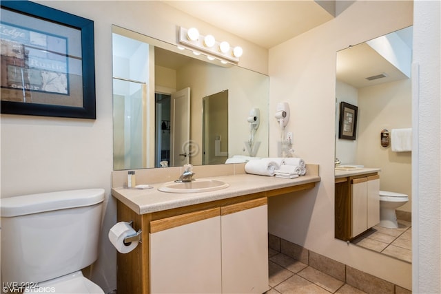 bathroom with tile patterned flooring, vanity, and toilet