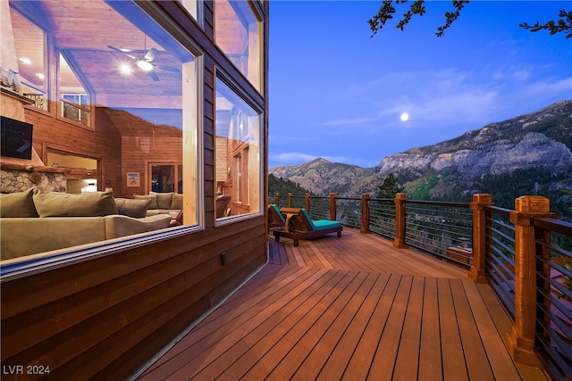 deck at dusk featuring a mountain view