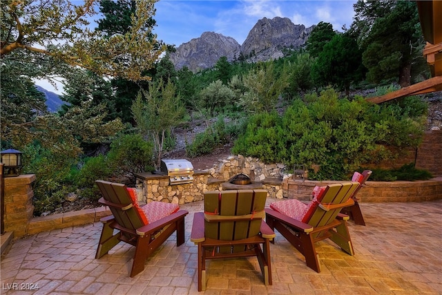 view of patio / terrace featuring an outdoor kitchen, a mountain view, and grilling area