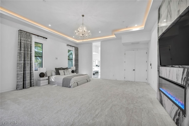 bedroom with a tray ceiling, recessed lighting, carpet flooring, and an inviting chandelier