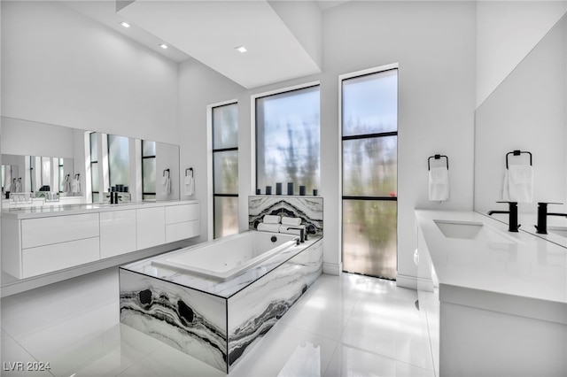 bathroom with a bath, tile patterned flooring, and vanity