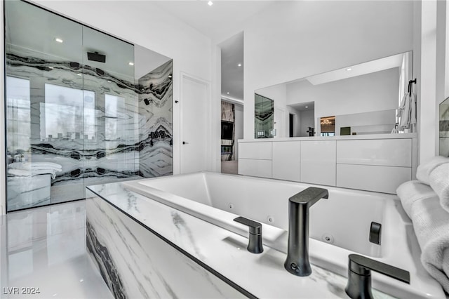 bathroom with a sink, a jetted tub, and a marble finish shower