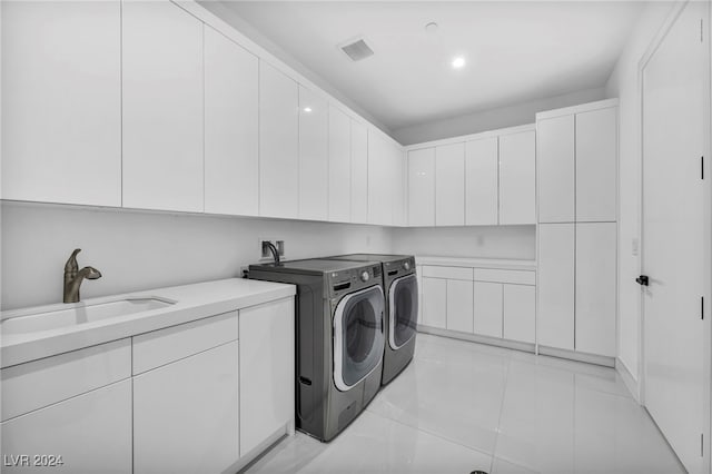 laundry area featuring cabinet space, visible vents, light tile patterned flooring, a sink, and washer and dryer