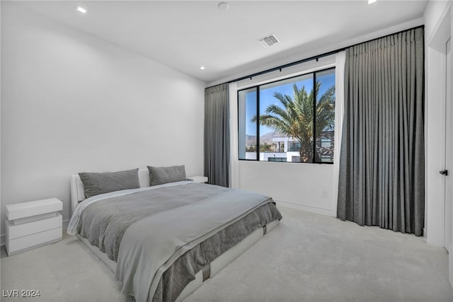 carpeted bedroom with visible vents and baseboards