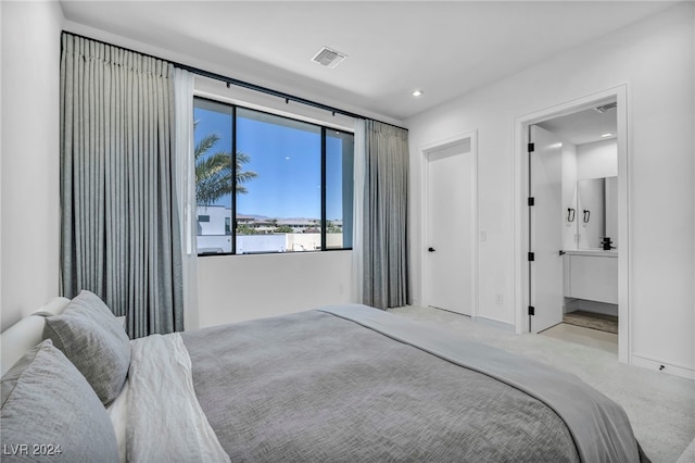 carpeted bedroom featuring baseboards, connected bathroom, visible vents, and recessed lighting