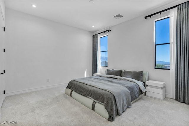 carpeted bedroom with baseboards, multiple windows, visible vents, and recessed lighting