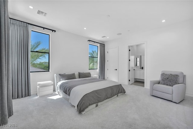 carpeted bedroom with ensuite bathroom, visible vents, and recessed lighting