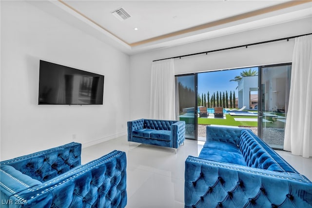 living room featuring recessed lighting, a raised ceiling, visible vents, and baseboards