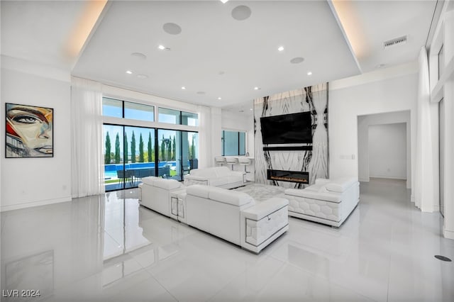 living room with recessed lighting, visible vents, and a high end fireplace