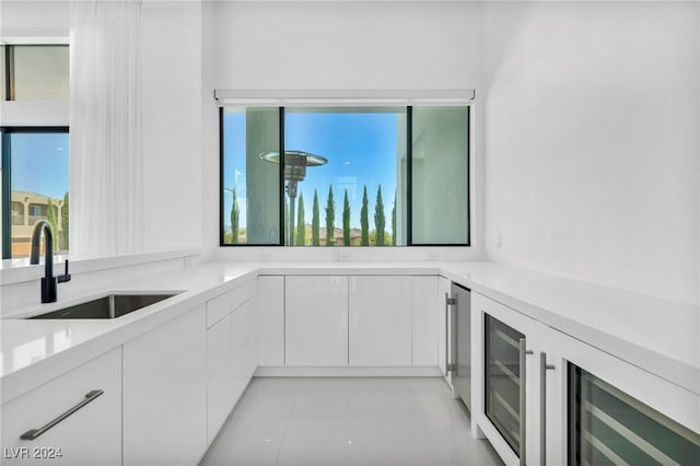 kitchen with modern cabinets, white cabinets, a sink, and light countertops