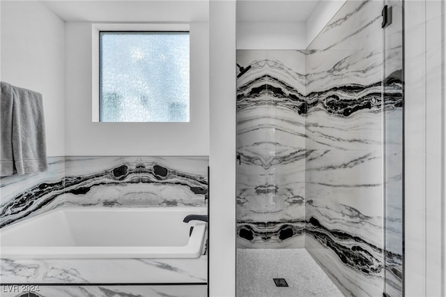 full bathroom with a marble finish shower and a bath