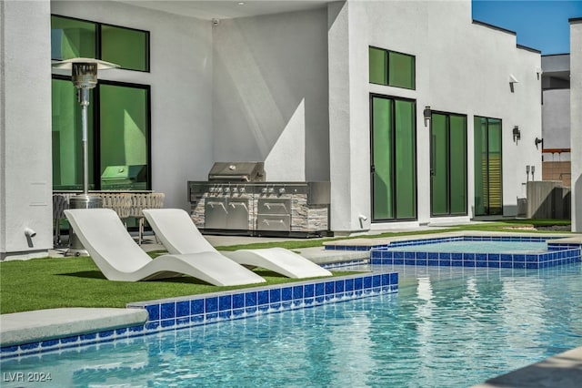 view of pool with an outdoor kitchen and a pool with connected hot tub