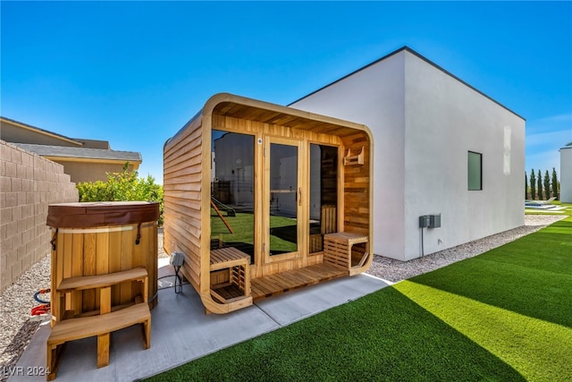 view of outbuilding featuring fence and a hot tub