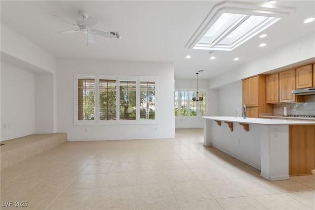 1629 Black Fox Canyon Rd, Henderson, NV 89052 - kitchen with a skylight, light countertops, recessed lighting, open floor plan, and under cabinet range hood