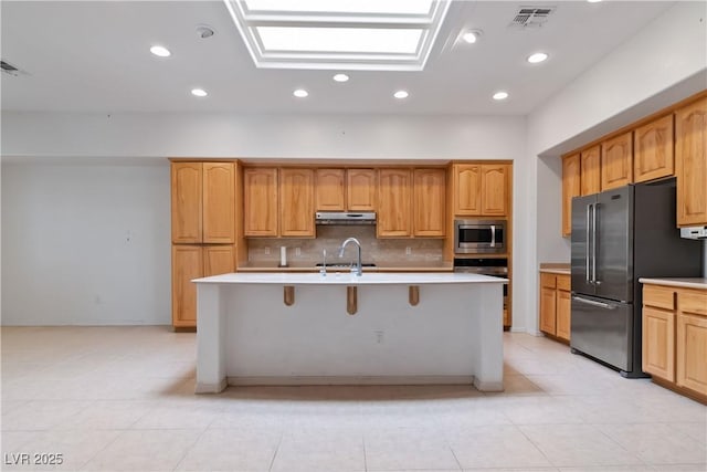 1629 Black Fox Canyon Rd, Henderson, NV 89052 - kitchen with stainless steel appliances, under cabinet range hood, light countertops, backsplash, and light tile patterned floors