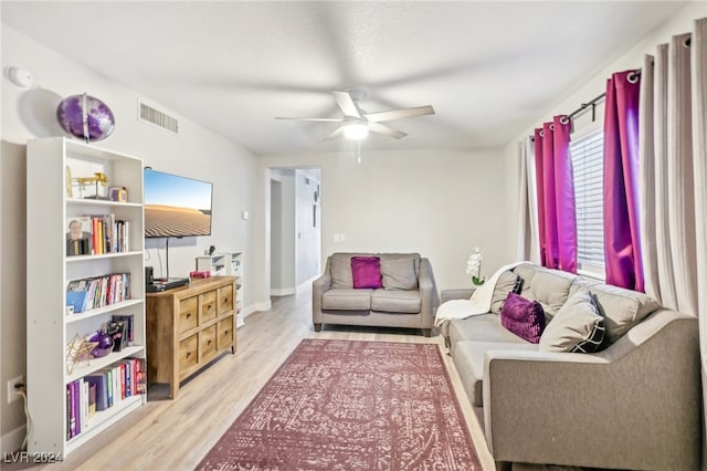 living room featuring ceiling fan and light hardwood / wood-style flooring