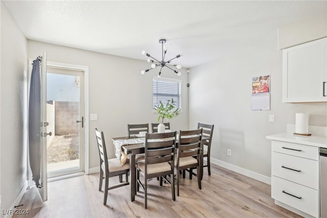 dining space featuring a textured ceiling, an inviting chandelier, and light hardwood / wood-style flooring