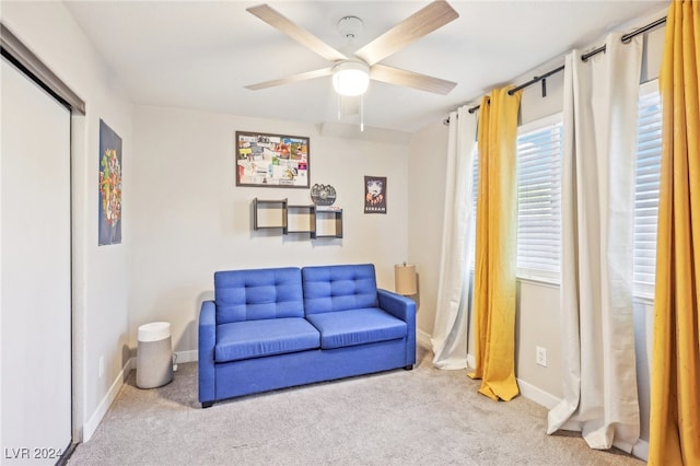 sitting room with ceiling fan and carpet flooring