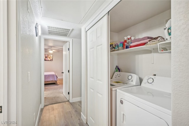 laundry area featuring ceiling fan, light hardwood / wood-style floors, and washer and dryer