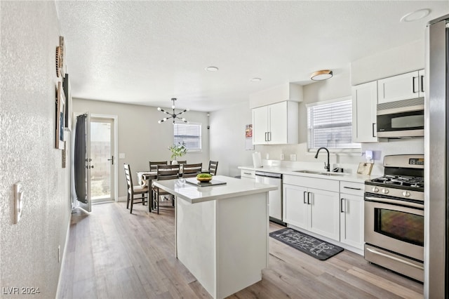 kitchen featuring white cabinets, appliances with stainless steel finishes, plenty of natural light, and sink