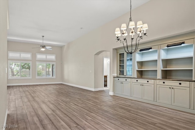 interior space featuring ceiling fan with notable chandelier and light wood-type flooring