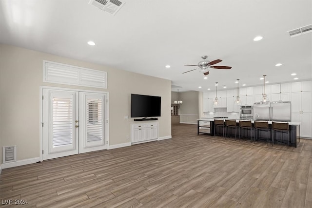 living room with ceiling fan, french doors, and light hardwood / wood-style flooring