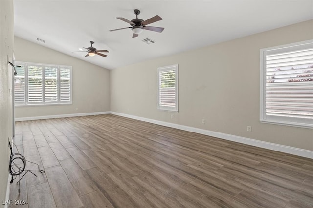 unfurnished room featuring a wealth of natural light, hardwood / wood-style floors, and vaulted ceiling