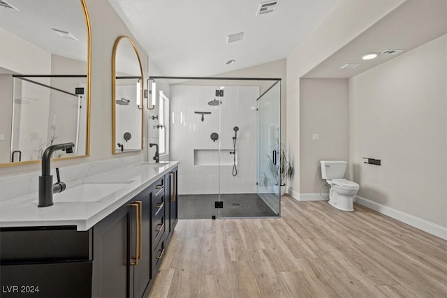 bathroom with vanity, hardwood / wood-style floors, lofted ceiling, toilet, and a shower with shower door