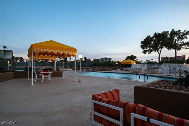 pool at dusk with a patio