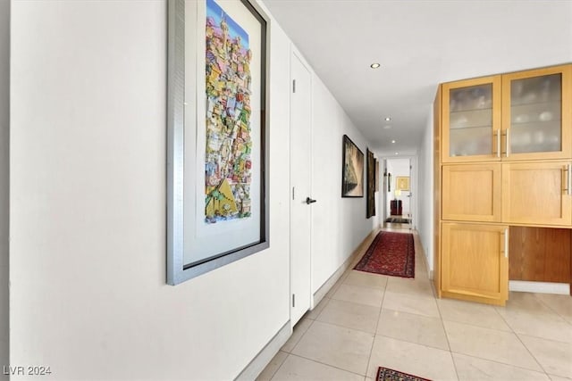 hallway featuring recessed lighting, baseboards, and light tile patterned floors