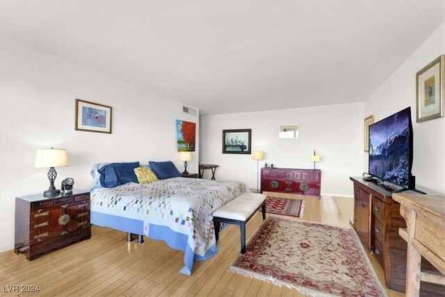 bedroom with visible vents, baseboards, and wood finished floors