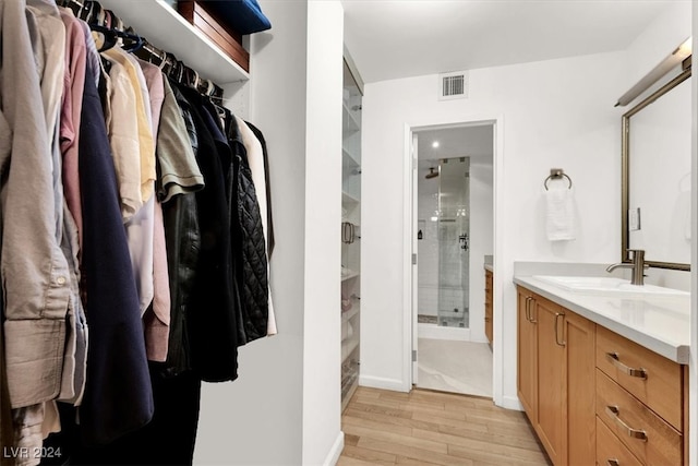 bathroom with hardwood / wood-style flooring, an enclosed shower, and vanity