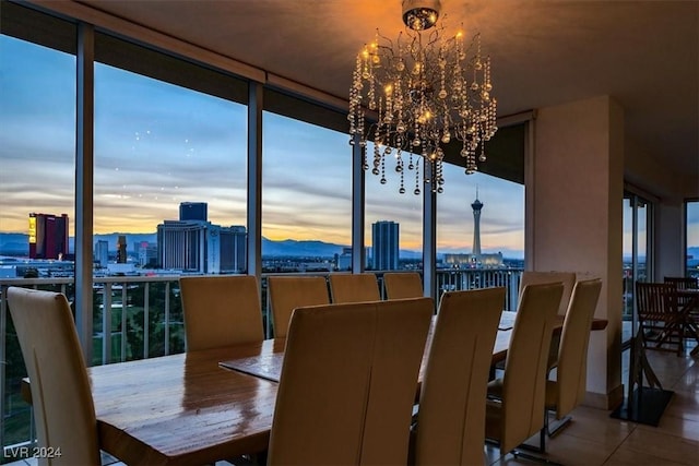 dining room featuring tile patterned flooring, a view of city, and a chandelier