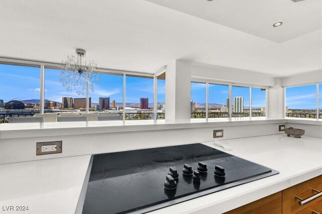 kitchen with black electric cooktop and a notable chandelier